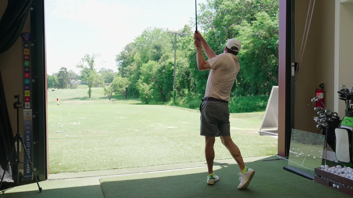 A golfer being analysed on the outdoor range.